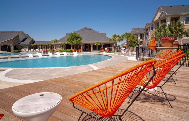 a swimming pool with orange chairs