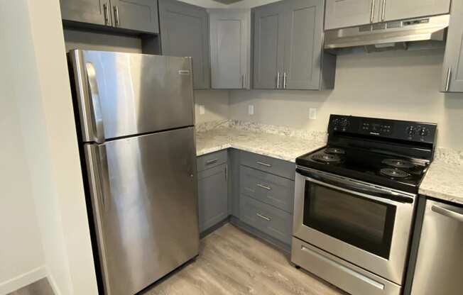 a kitchen with stainless steel appliances and marble counter tops  at The Lakes Apartments, Washington, 98837