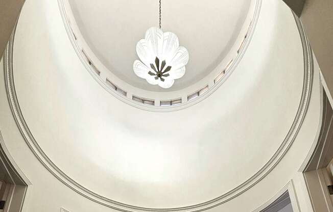 A spiral staircase with a chandelier hanging from the ceiling.