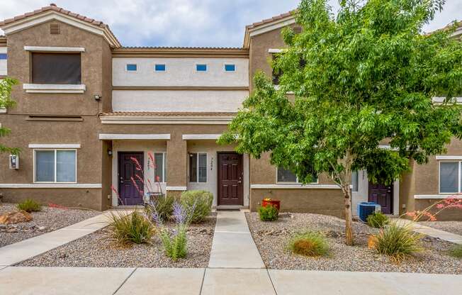 a building with a tree and a sidewalk in front of it