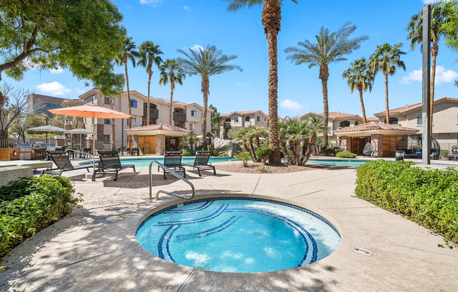 A pool surrounded by palm trees and lounge chairs.