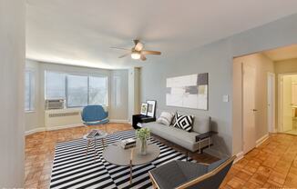 a living room with a couch and a table and a ceiling fan