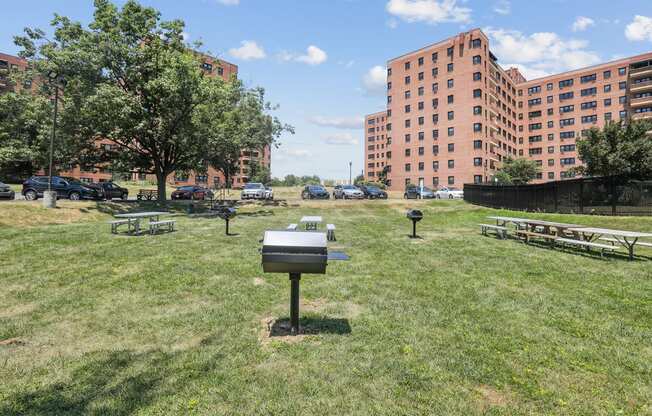 a city park with buildings in the background and a mailbox