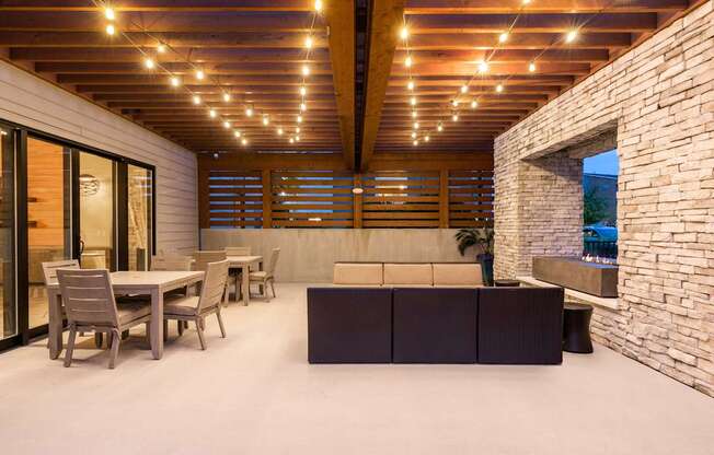 A modern outdoor dining area with a table and chairs.