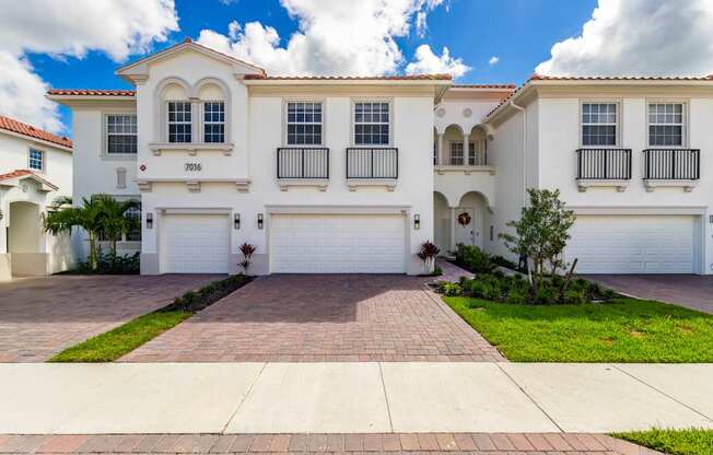 A white house with a red roof and a garage door.
