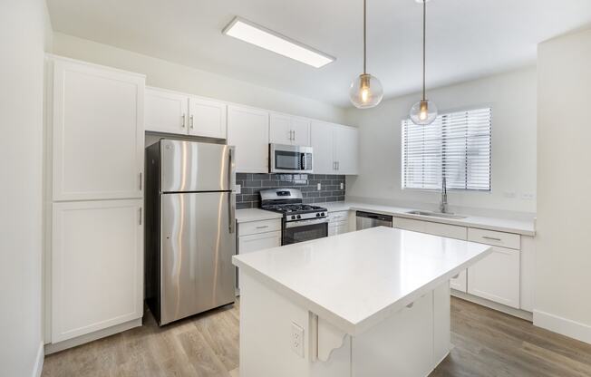 Experience the epitome of modern elegance at The Michael B apartments, where sleek white cabinetry meets state-of-the-art stainless steel appliances, setting the stage for gourmet culinary adventures.