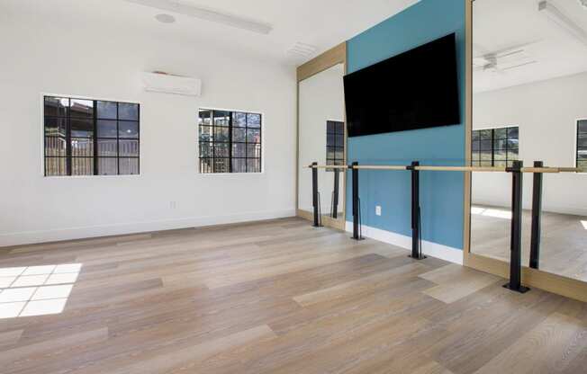 a large room with a tv on the wall and wood floors