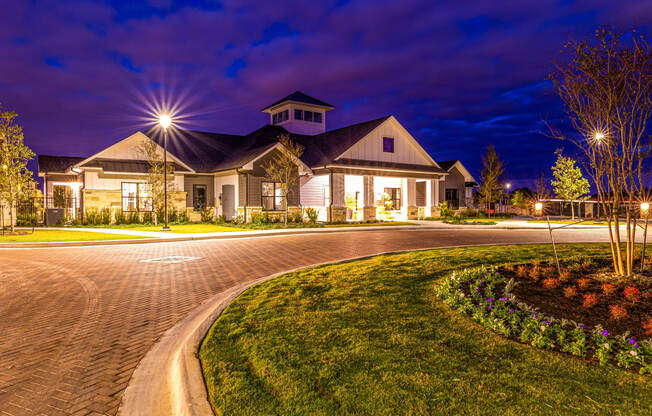 House with a driveway and a street at night at The Parker Austin, Pflugerville, TX