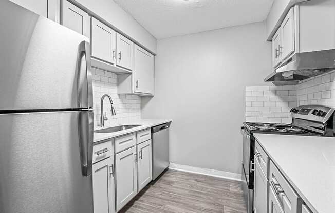 a kitchen with white cabinets and stainless steel appliances