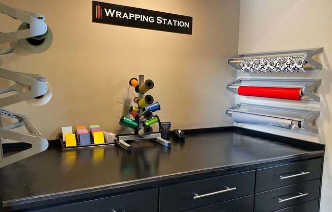 A black countertop with a variety of wrapping paper and a sign that says