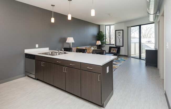 Modern open-concept kitchen and living area with stainless steel appliances.