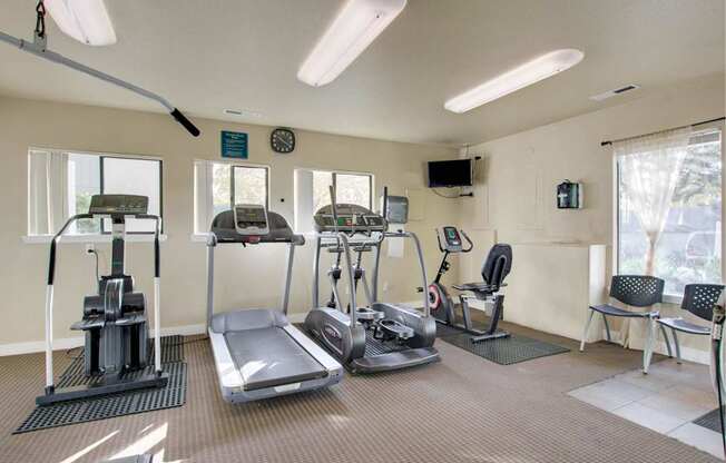 A gym with treadmills, elliptical machines, and other exercise equipment.