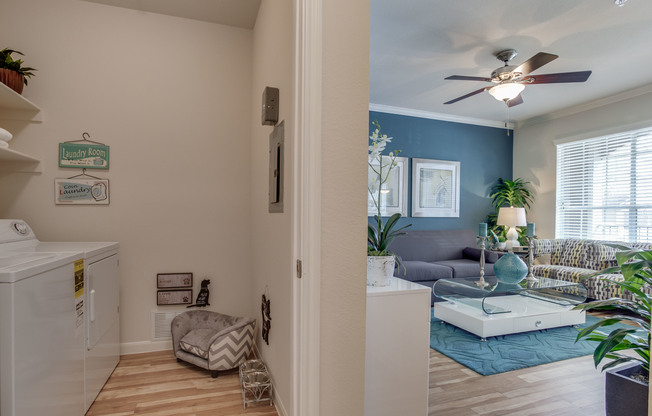 View of Laundry Room with Washer, Dryer, and View of Living Room at Raveneaux Apartments