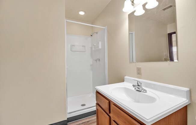 A bathroom with a white sink and a mirror above it.
