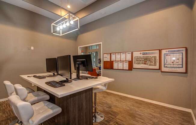 A modern office with a white desk and two chairs.