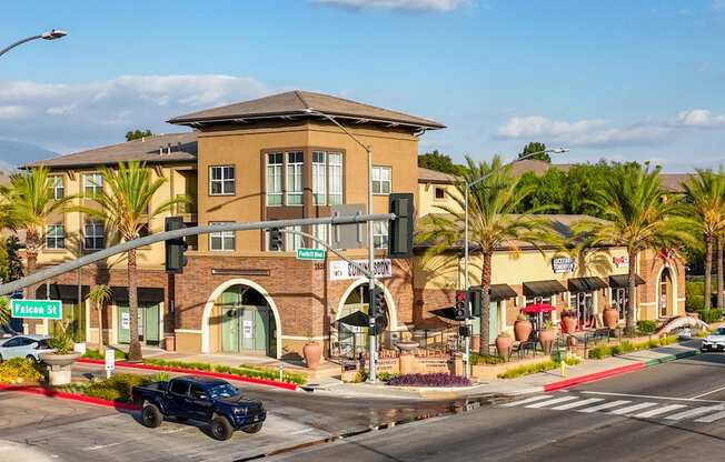 A black truck is driving on a street with a building in the background.