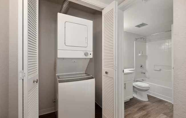 a small bathroom with a washer and dryer in a closet at Rush River Apartments, California