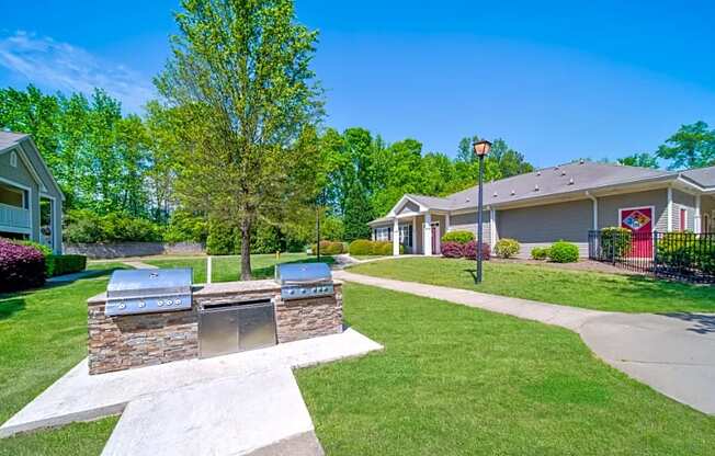 a patio with two barbecue pits in front of a house