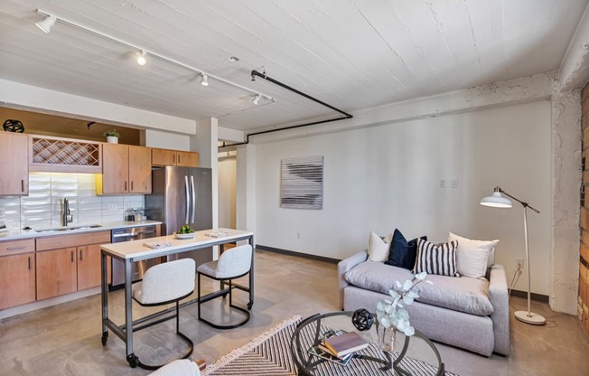 a living room with a couch and a kitchen with a table and chairs