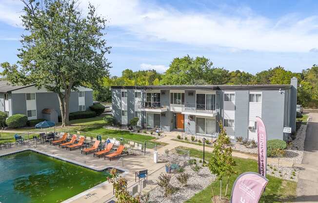 A sunny day at a poolside with chairs and a banner.