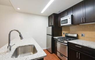 a kitchen with a sink stove refrigerator and microwave