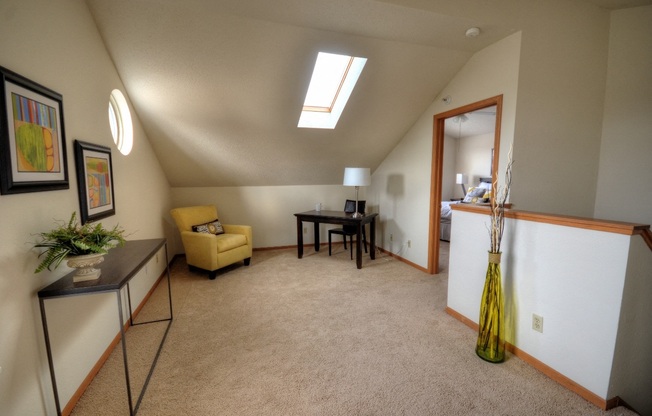 a living room with a couch and a table and a door to a dining room