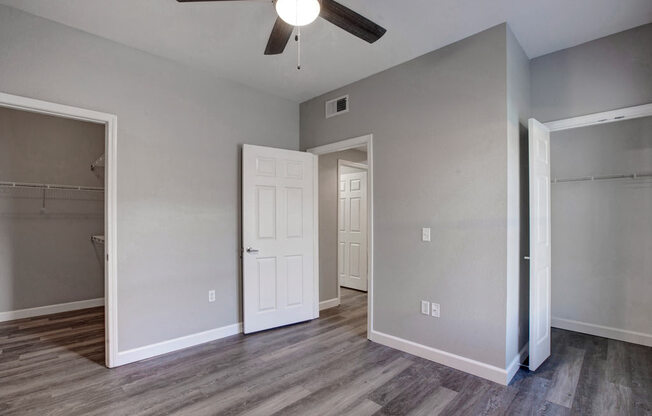 a bedroom with a ceiling fan and a closet