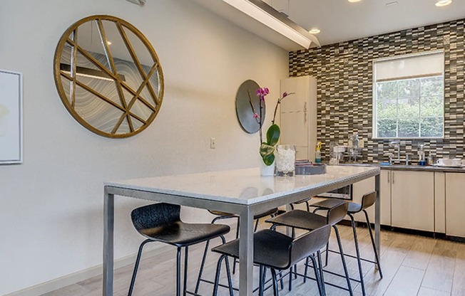 a kitchen with a long table with four stools