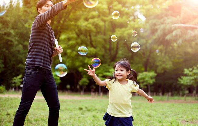 Father and daughter having fun in park with Soap Bubbles iStock-501485932.jpg