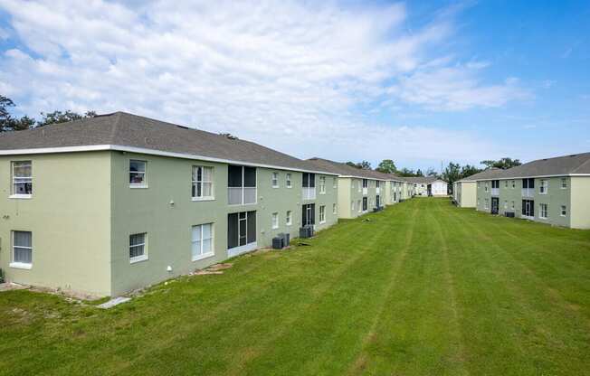 A long row of identical houses with green lawns.