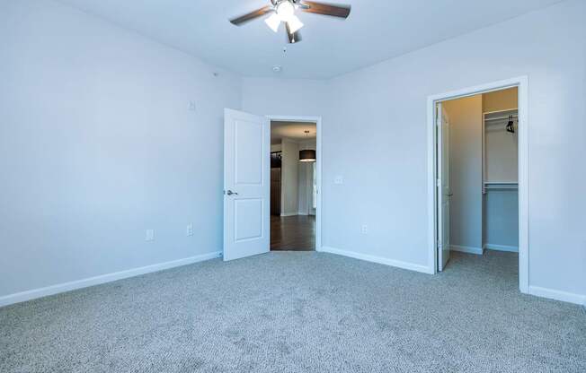 A room with a ceiling fan and carpeted floor.