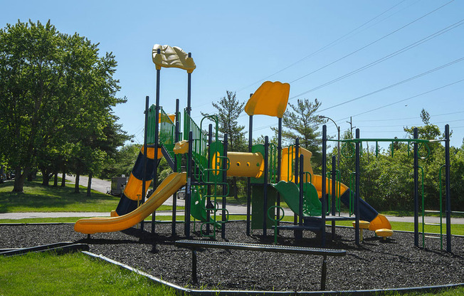 a playground with yellow and green equipment on a sunny day