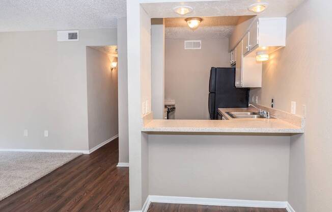 A kitchen area with a sink and a refrigerator.