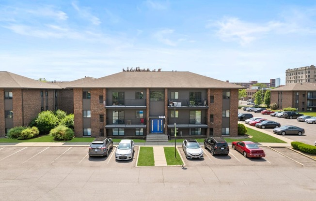 a large brick apartment building with a parking lot in front of it at Lafayette Park Place, Detroit, MI, Detroit, MI