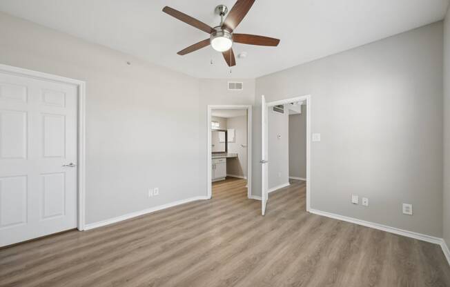 an empty living room with a ceiling fan