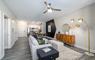 a living room with a white couch and a ceiling fan