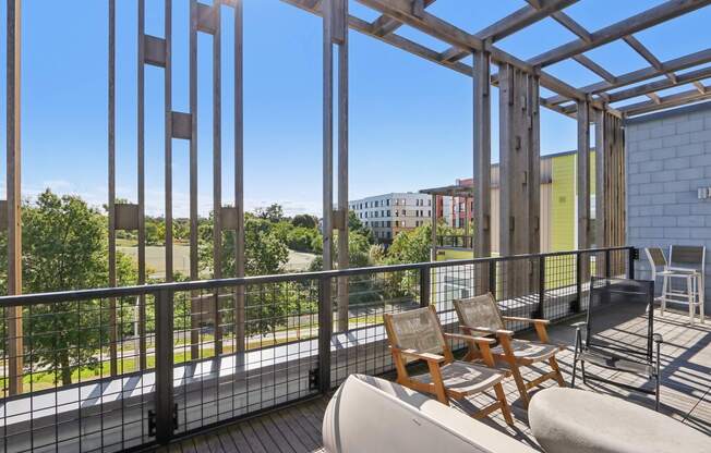 Balcony with a table and chairs overlooking a green area at Park77 Apartments, Cambridge, 02138