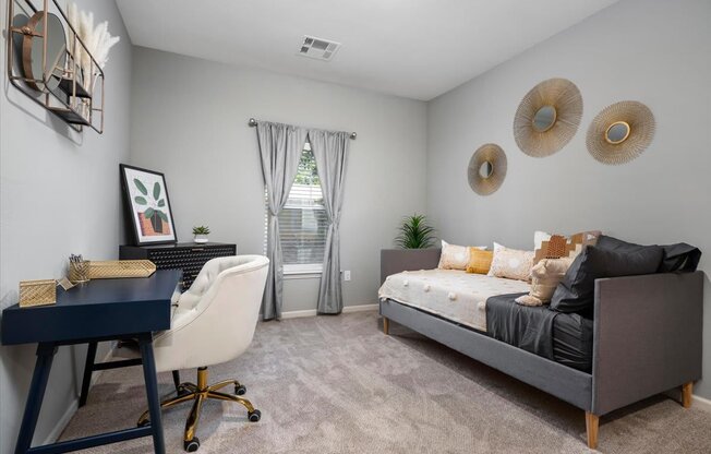 a bedroom with a couch and a desk
