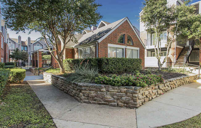 A house with a stone wall in front.