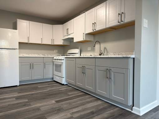 A kitchen with white appliances and cabinets.
