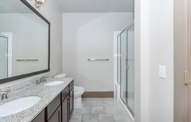 a bathroom with two sinks and a shower and a toilet