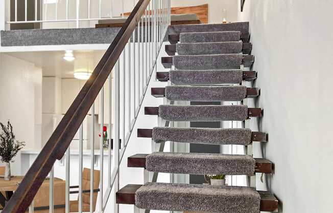 a staircase with carpeted steps and a wooden railing