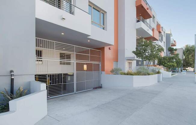 A modern building with a white and orange facade and a metal fence at Woodley Sara Apartment, California, 91406