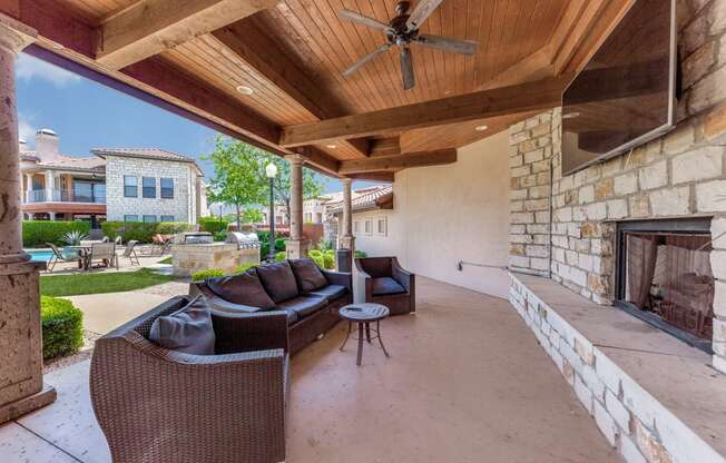 a covered patio with couches and a fireplace