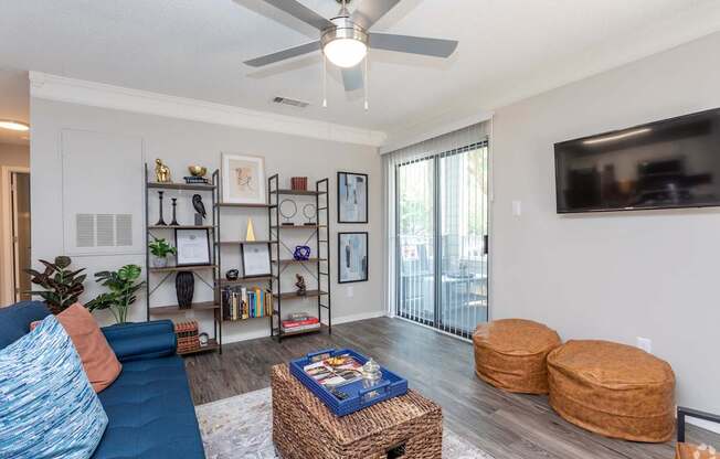 a living room with a ceiling fan and a tv