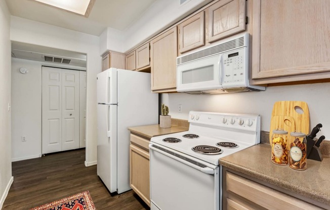 a kitchen with white appliances and wooden cabinets