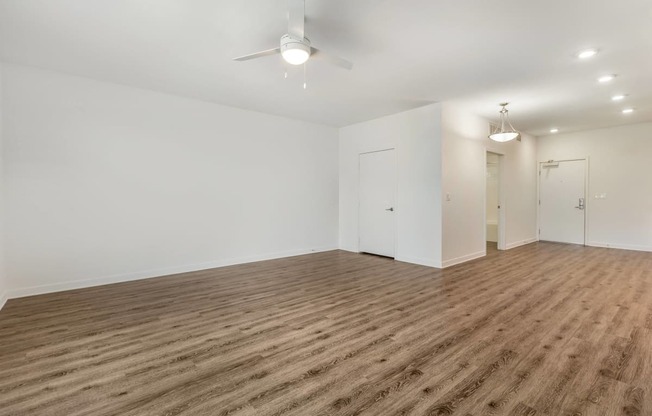 a living room with white walls and wood flooring and a ceiling fan at Metro Gateway, Riverside, 92503