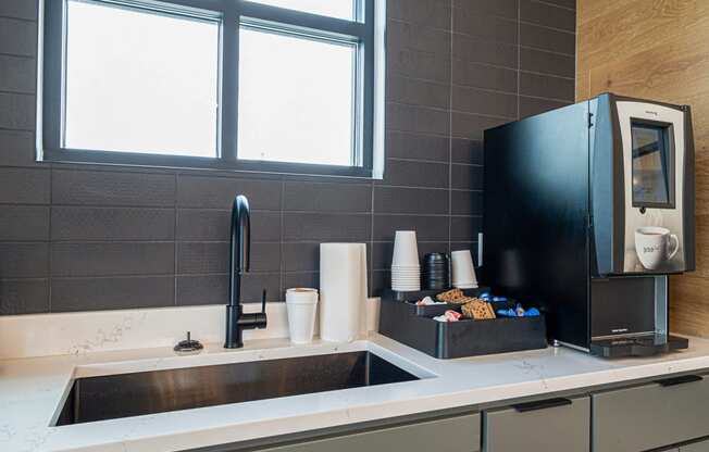 a kitchen with a sink and a coffee maker