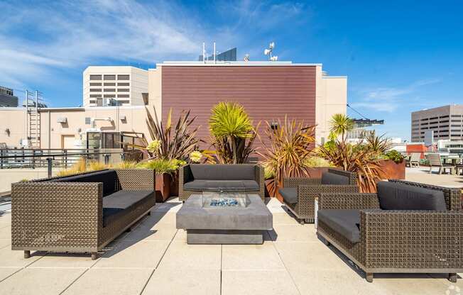 A patio with a table and chairs surrounded by plants.