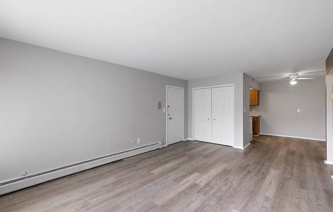 an empty living room with wood flooring and white walls